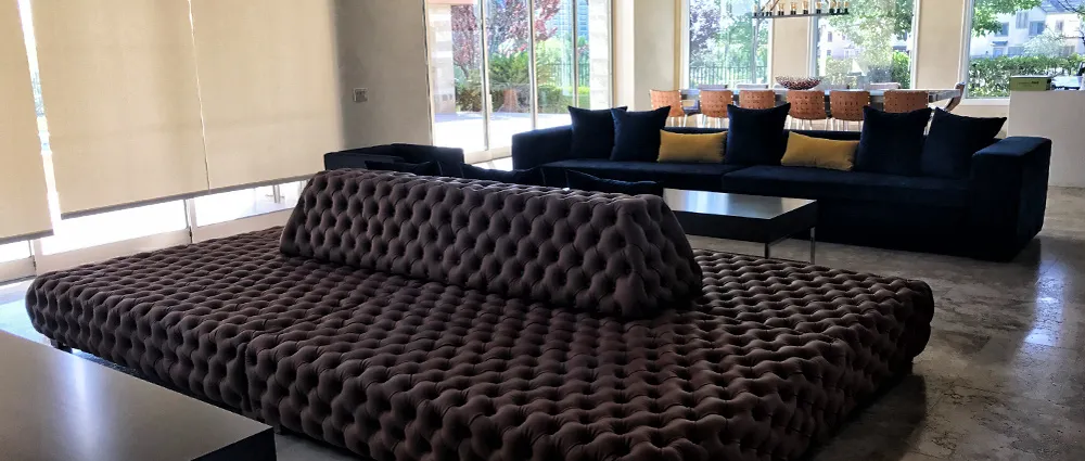 Tufted lounge seating and window shades in a hotel lobby