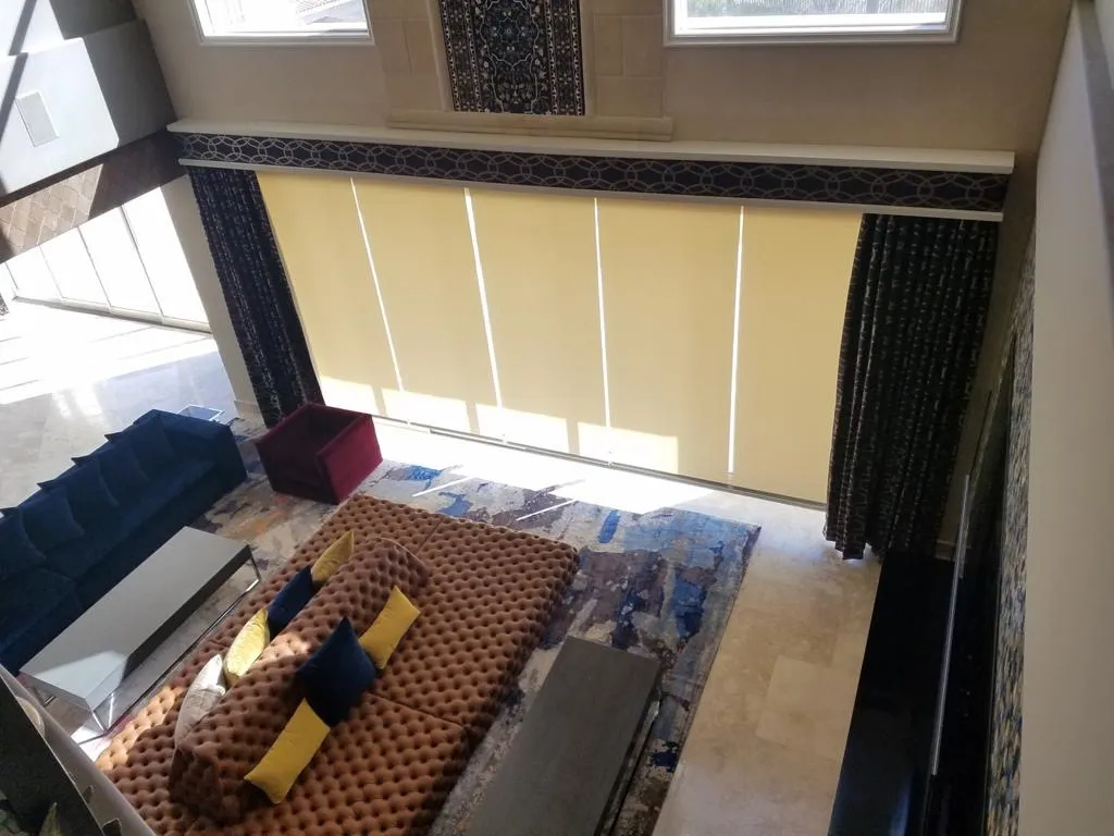 Two-story great room with roller shades and patterned side panels